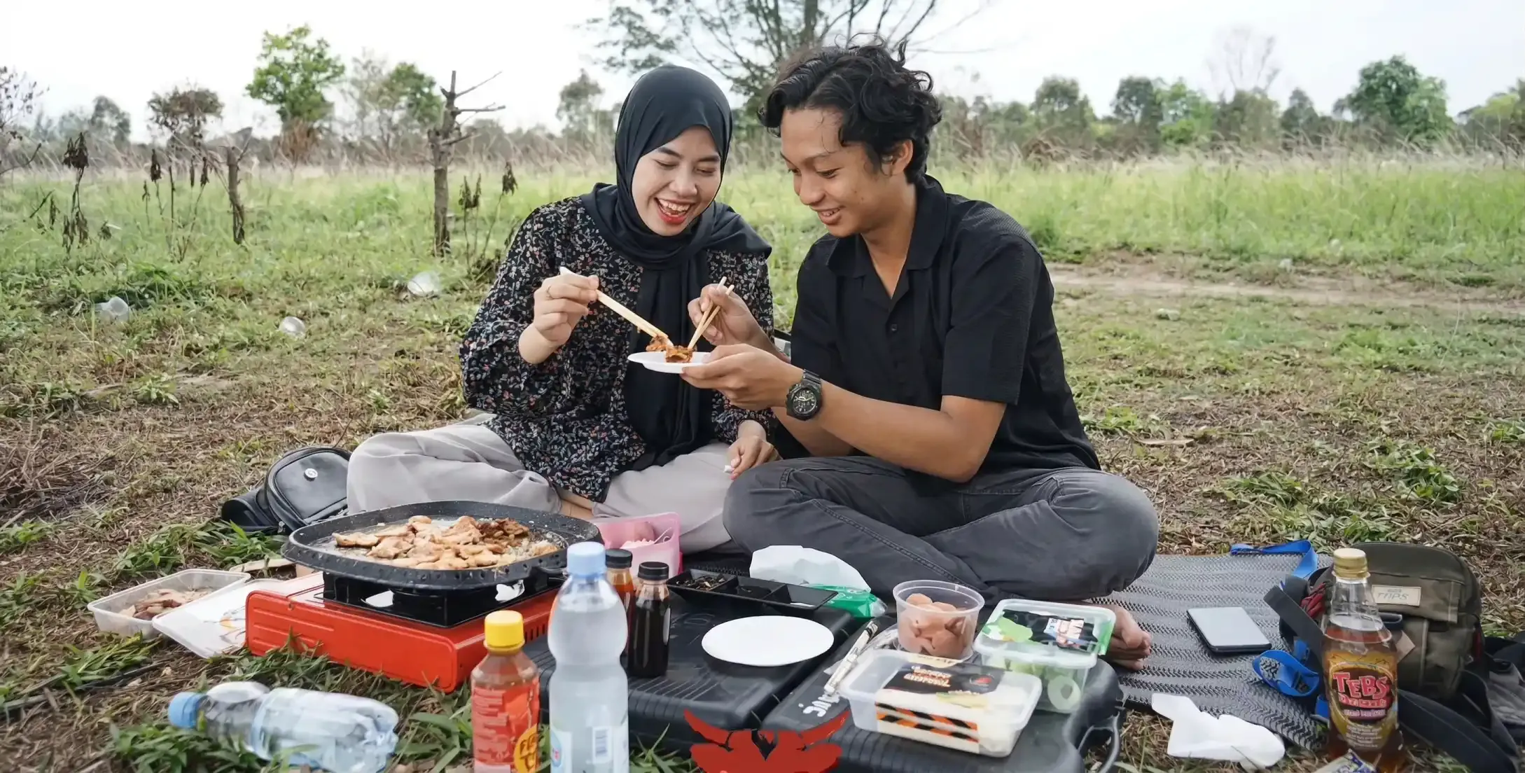 Pasangan nge-grill paket Home Service Batavia di lapangan rumput
