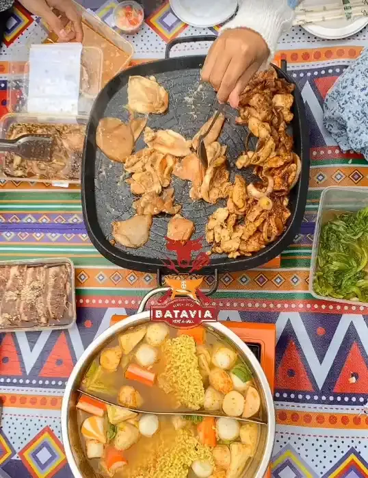 Grill dan steamboat dilihat dari atas di atas taplak motif